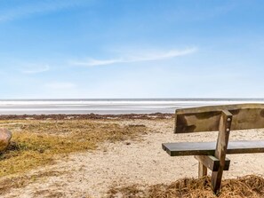 A bench on a sandy beach with a view of the ocean. - "Ioar" - 10m from the sea by Interhome (Bjert)