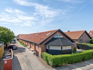 Eine Wohnstraße mit Häusern, blauem Himmel und Asphaltstraße.