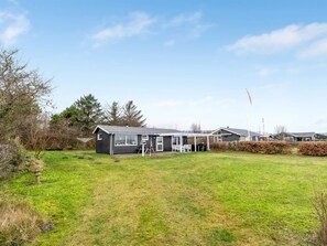 A residential property with a house, a covered outdoor seating area, and a flagpole. - "Richard" - 400m from the sea by Interhome (Frederikshavn)