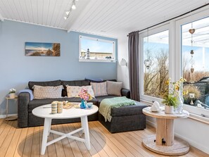 A modern living room with a grey sofa, a white coffee table, and a round wooden side table. - "Richard" - 400m from the sea by Interhome (Frederikshavn)