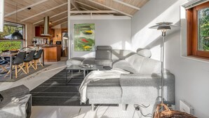A modern interior with a dining area, sofa, and a large painting.