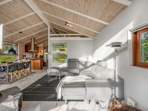 Ein modernes Interieur mit Essbereich, Sofa und einem großen Gemälde.