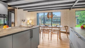 Eine moderne Küche mit einer großen Kochinsel, einem Holzespeisetisch und Stühlen.