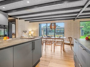 Eine moderne Küche mit einer großen Kochinsel, einem Holzespeisetisch und Stühlen.