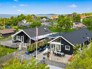 Un quartier résidentiel avec des maisons, une terrasse en bois et une vue sur l’eau.