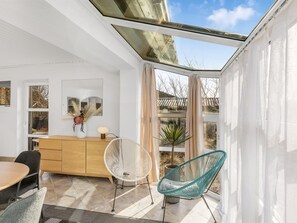 A modern room with a skylight, a wooden cabinet, a dining table, and two chairs. - "Falk" - 900m from the sea by Interhome (Bindslev)