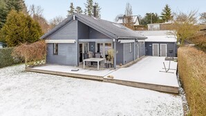 A two-story house with a covered patio, a garage, and a fenced yard. - "Algut" - 80m from the sea by Interhome (Haderslev)