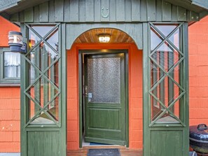 A green wooden door with a textured glass panel, flanked by diamond-patterned glass windows, and an arched entrance. - "Saxe" - 1km from the sea by Interhome (Løkken)