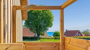 Eine Holzterrasse mit Blick auf Bäume und Häuser.