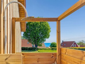 Eine Holzterrasse mit Blick auf Bäume und Häuser.