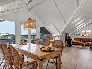A spacious dining area with a wooden table, wicker chairs, and a hanging light fixture. - "Kajsa" - 150m from the sea by Interhome (Assens)