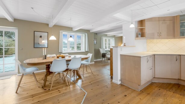 A spacious kitchen with wooden cabinets, a dining area with a round table, and large windows. - "Synnöve" - 1.7km to the fjord by Interhome (Tim)