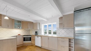 A modern kitchen with wooden cabinets, a stainless steel refrigerator, and a window providing natural light. - "Synnöve" - 1.7km to the fjord by Interhome (Tim)