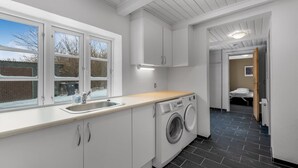 A modern kitchen with a built-in washing machine, a sink, and a window with a view of the outside. - "Synnöve" - 1.7km to the fjord by Interhome (Tim)