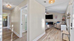 A spacious living area with a sofa, TV, and wooden flooring. - Candlewood Casa ~ 3BR/2BA 15 Mins to Beach! (Navarre)