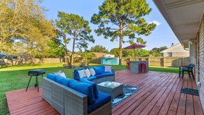 A deck with outdoor furniture, a barbecue grill, and a pool in the background. - Candlewood Casa ~ 3BR/2BA 15 Mins to Beach! (Navarre)