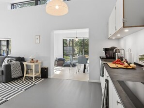 Eine moderne Küche mit Essbereich, einer Couch und einem großen Fenster.