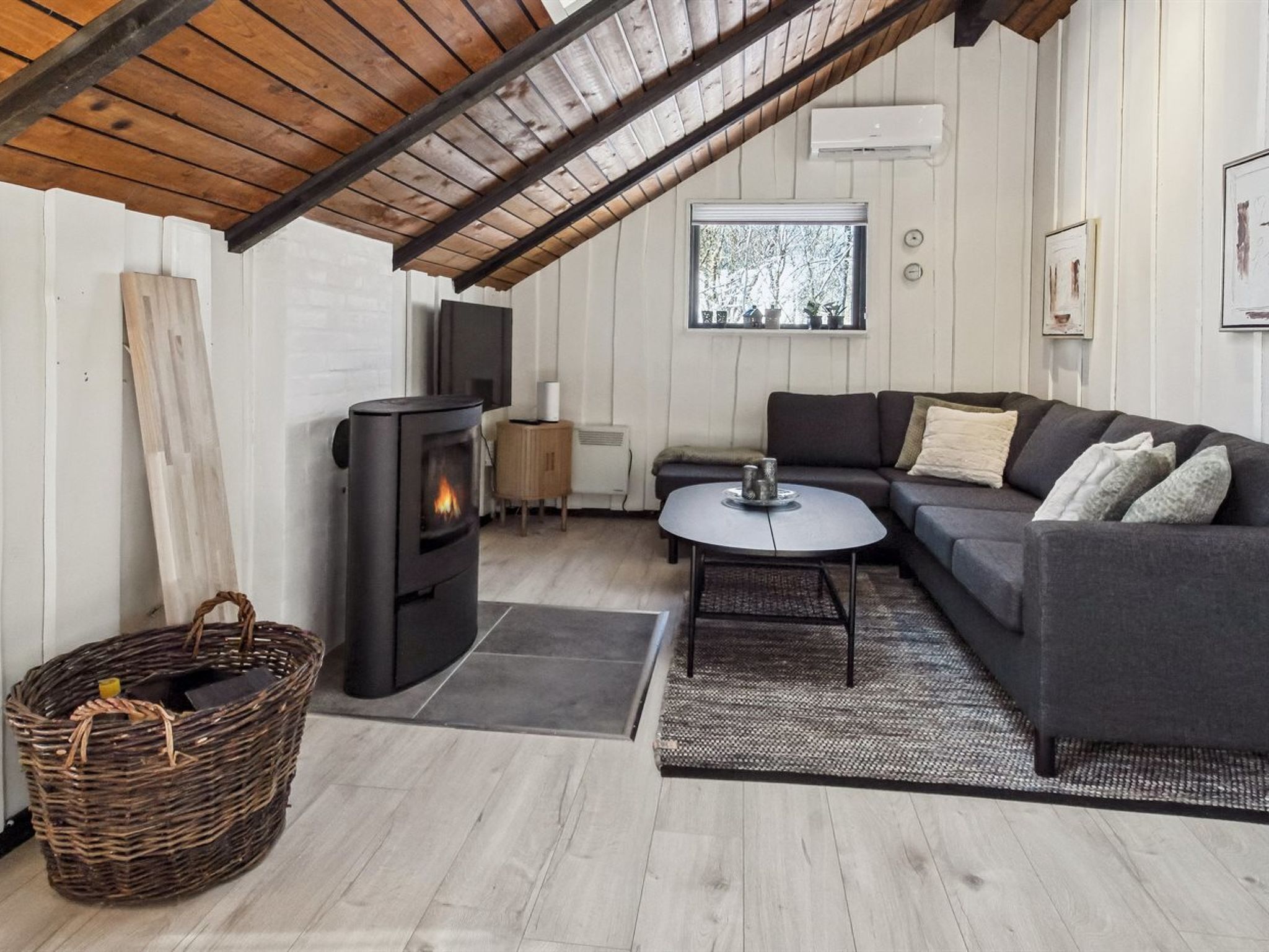 Une pièce confortable de style loft, dotée d’une cheminée, d’un canapé, d’une table basse et d’une grande fenêtre.