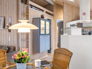 A wooden interior with a dining area, a kitchen, and a living space. - "Lien" - 100m from the sea by Interhome (Juelsminde)