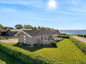 A modern house with a sloped roof, a covered porch, and a well-maintained lawn. - "Lien" - 100m from the sea by Interhome (Juelsminde)