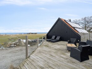 A modern outdoor deck with seating and a view of the sea. - "Carola" - 1km from the sea by Interhome (Svaneke)