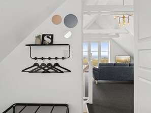 A modern interior with a coat rack, wall decor, and a view of the outdoors. - "Carola" - 1km from the sea by Interhome (Svaneke)