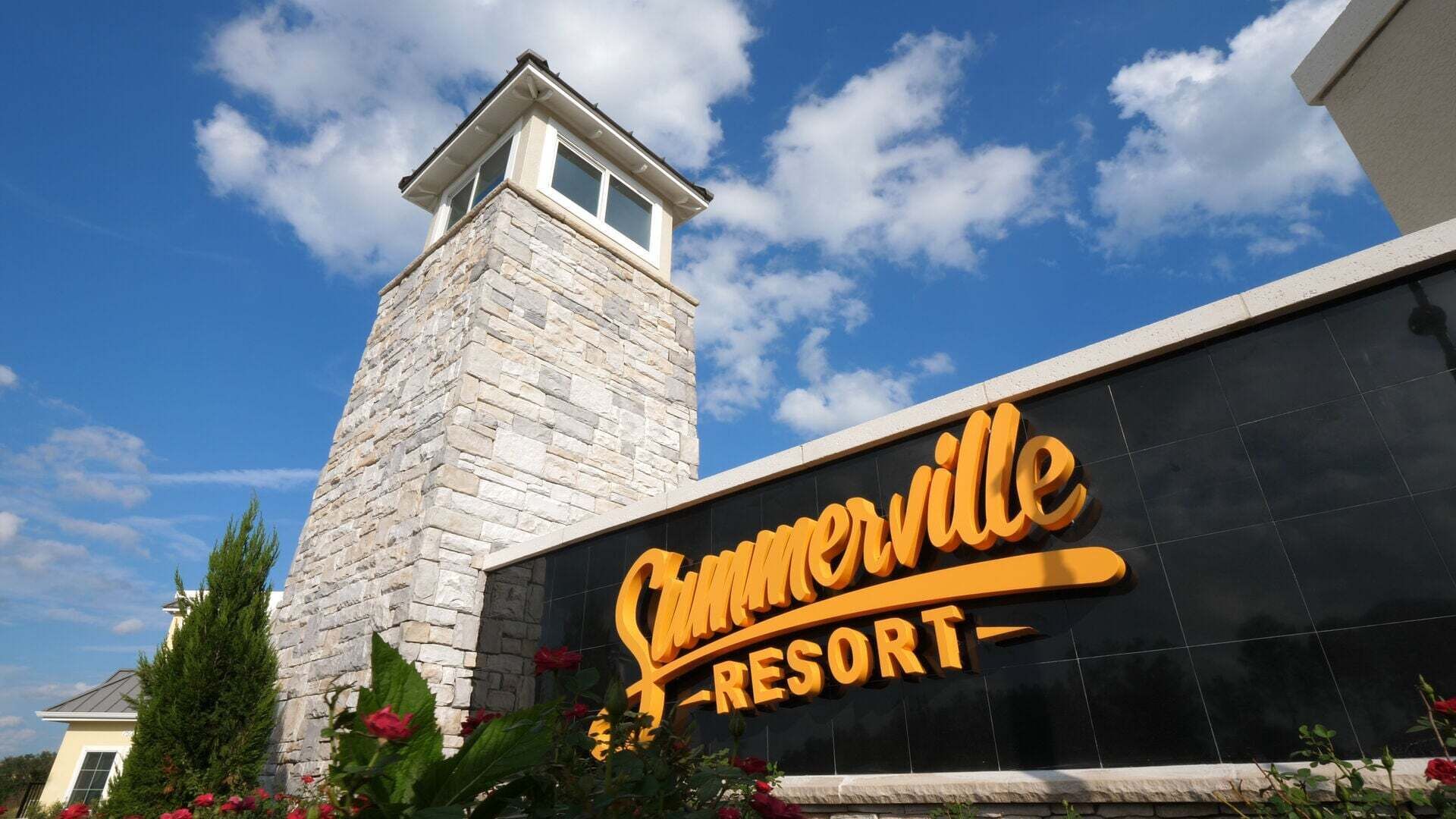 Une tour de pierre et un panneau indiquant le complexe hôtelier de Summerville.