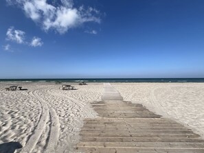 A sandy beach with a wooden boardwalk leading to the water, and picnic tables along the path. - "Saku" - 375m from the sea by Interhome (Slagelse)
