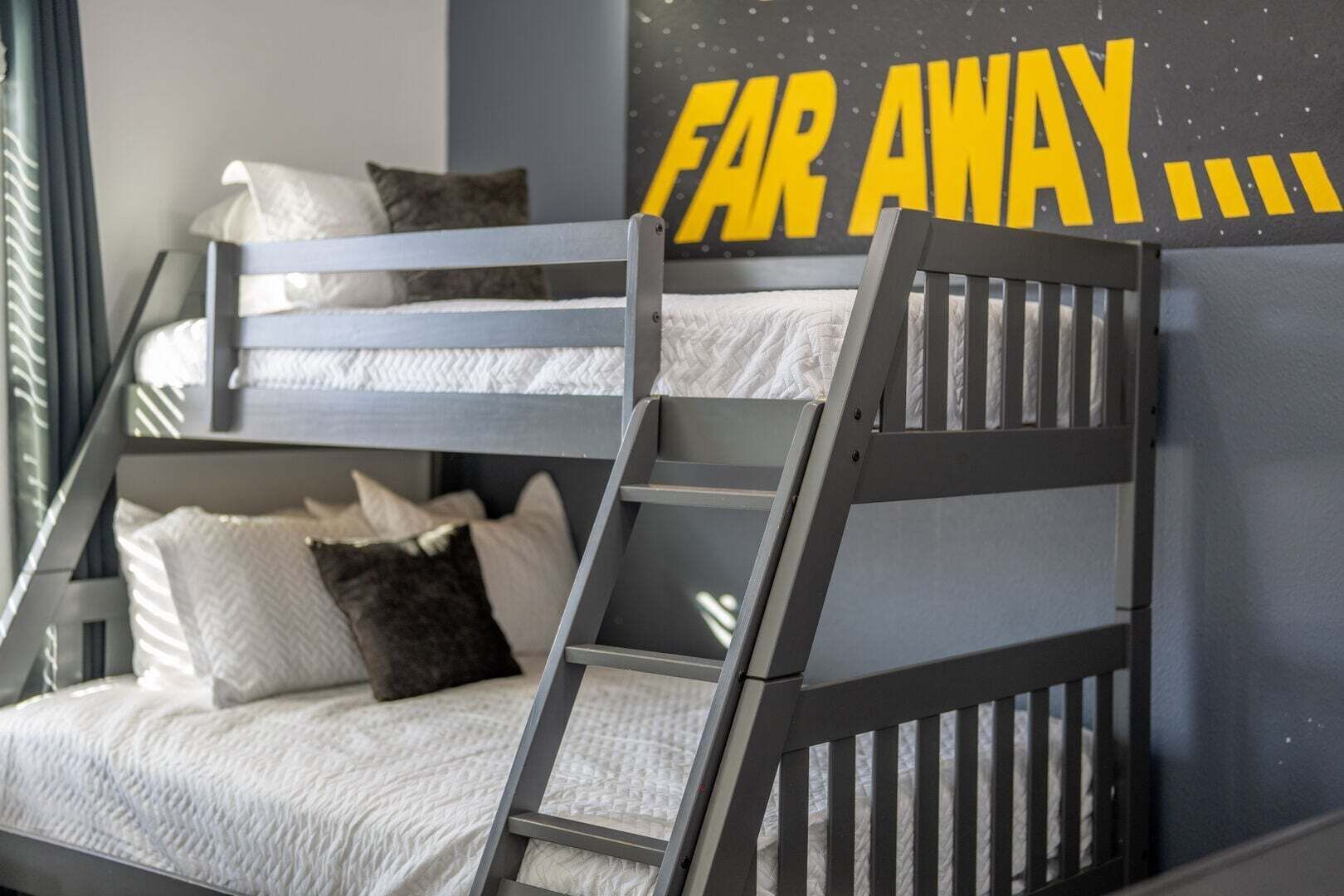 A bunk bed with a ladder, pillows, and a wall with the text 'FAR AWAY...'.