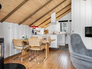 Eine moderne Küche mit Essbereich, Holzboden und einem an der Wand montierten Fernseher.