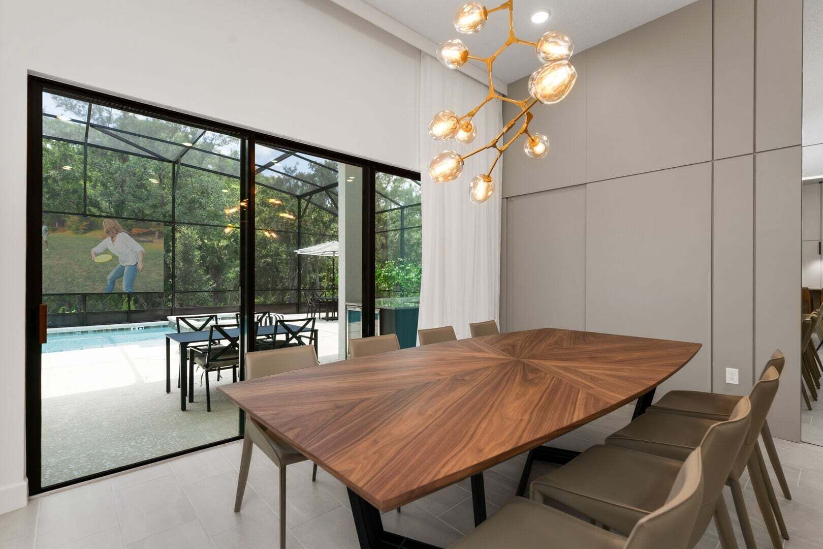 Un espace de restauration moderne, doté d’une grande table en bois, de chaises confortables et d’un lustre original.