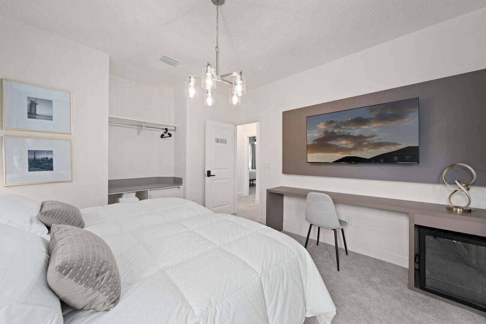 Une chambre moderne avec un grand lit, un bureau, une chaise et une cheminée.