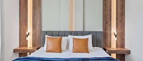 A modern bedroom with a large bed, two bedside tables, and a unique wall design.
