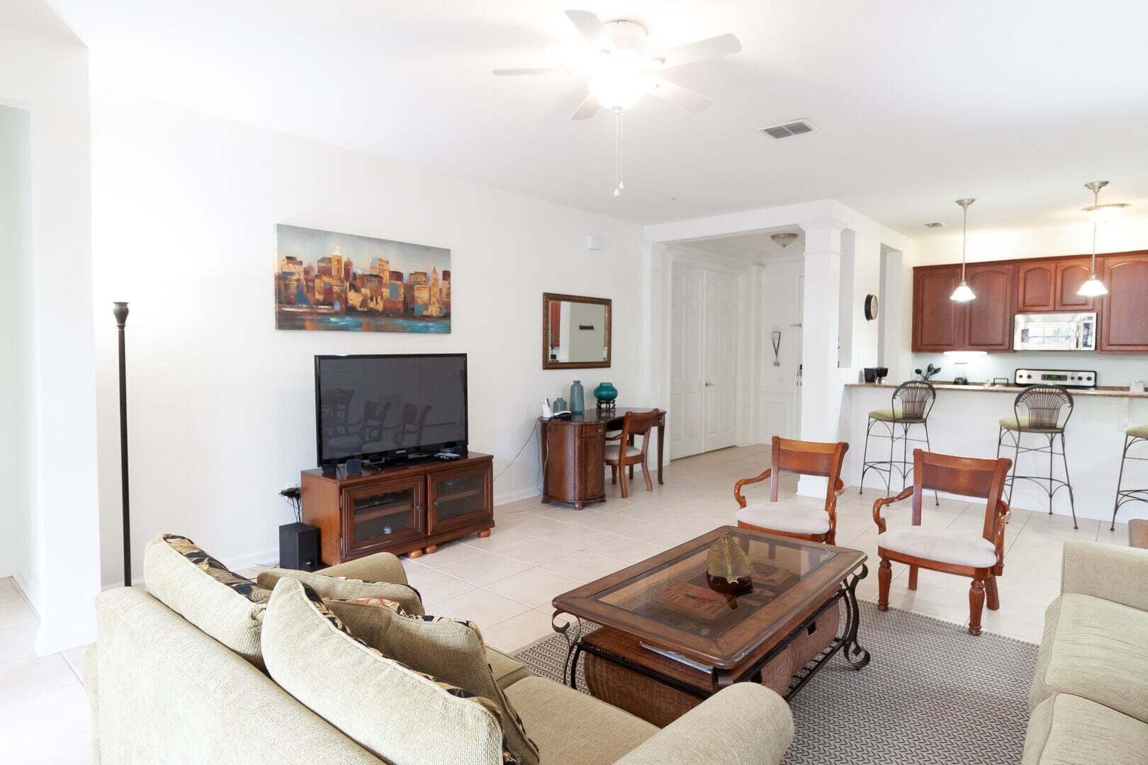 A living room with a television, sofa, coffee table, and a painting on the wall.