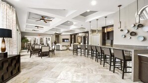 A spacious kitchen with a bar area, modern ceiling design, and a dining area with chairs and tables. - Spacious 5-bedroom Villa With Private Pool in Davenport (Davenport)
