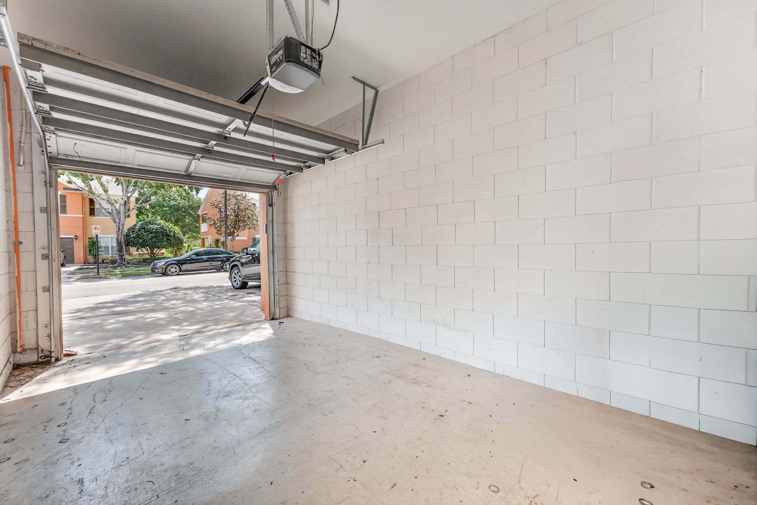 A parking garage with white brick walls and a concrete floor.