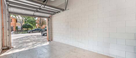 A parking garage with white brick walls and a concrete floor.