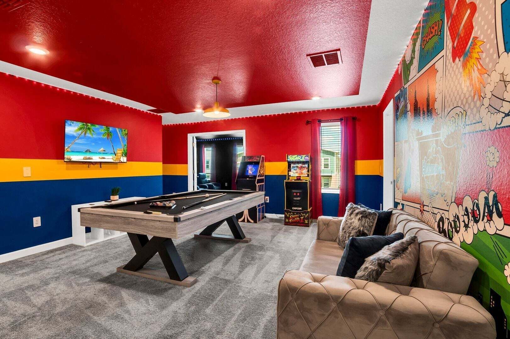 Une pièce équipée d’une table de billard, d’un canapé et d’une fresque murale.