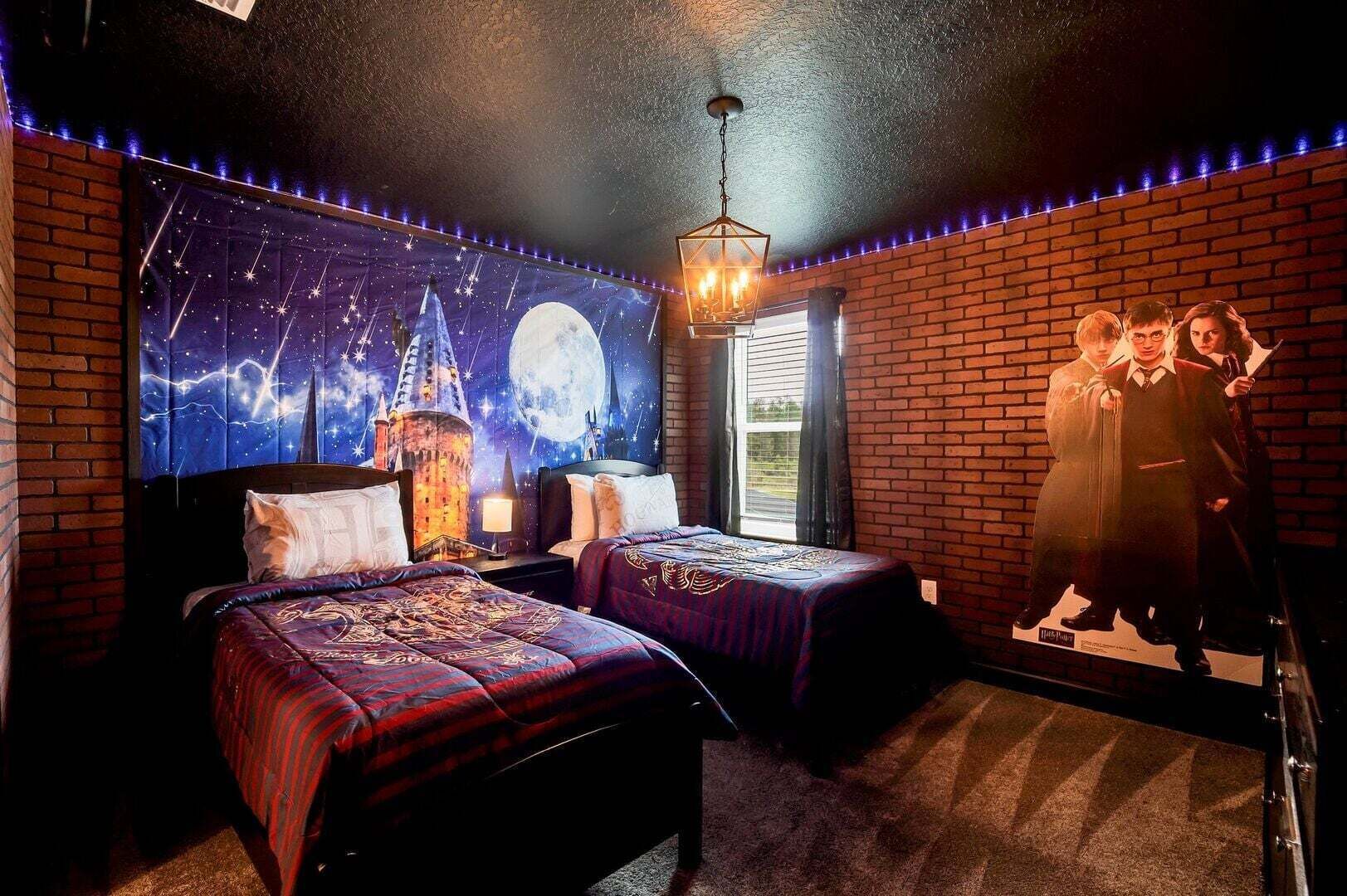A bedroom with two beds, a night sky mural, a castle image, and a window with curtains.