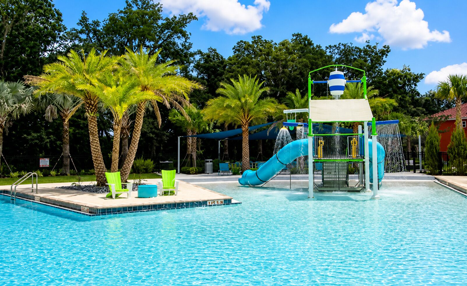 Ein Schwimmbad mit Wasserrutsche und Liegestühlen.