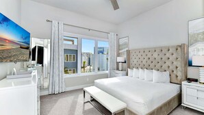 Een moderne hotelkamer met een groot bed, een bureau, een kaptafel en een raam met uitzicht op de stad.