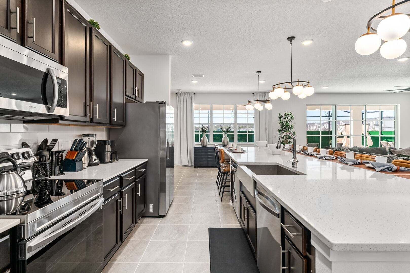 A modern kitchen with stainless steel appliances, a large island, and a view of the city.