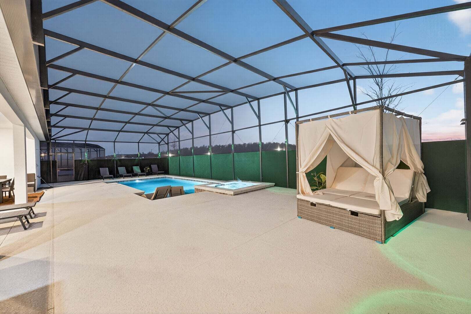 An indoor pool area with a glass ceiling, a hot tub, and a canopy bed.