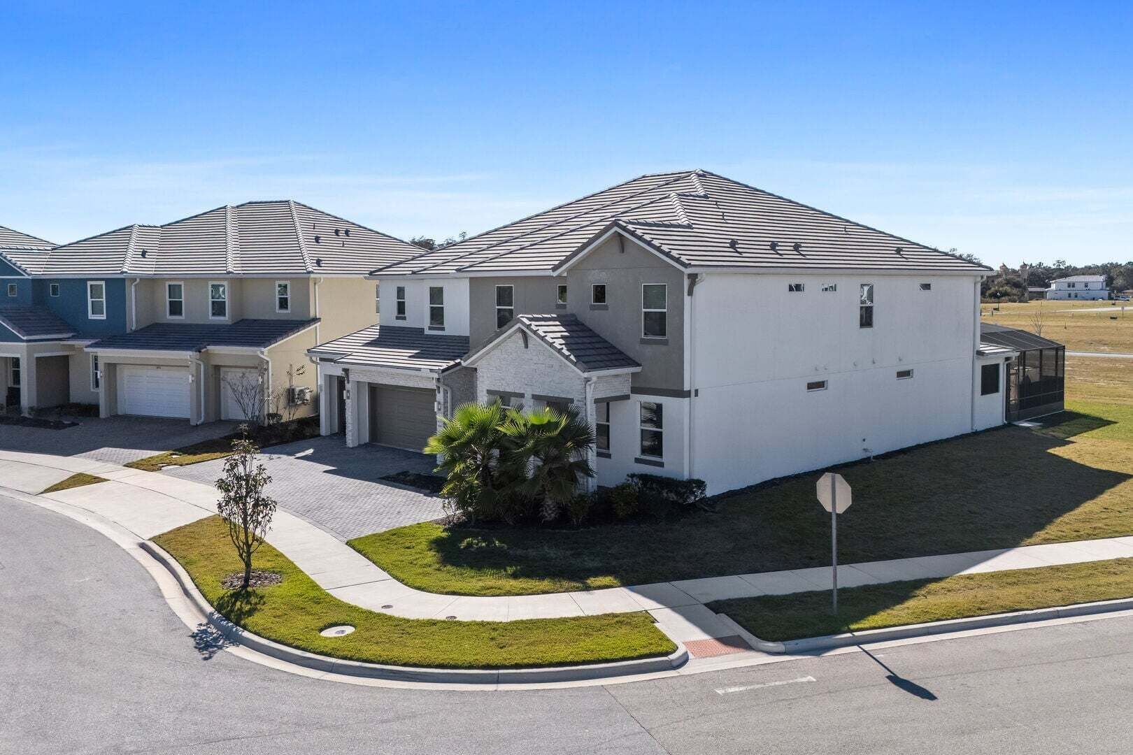 A modern residential building with a garage, a covered driveway, and a well-maintained lawn.