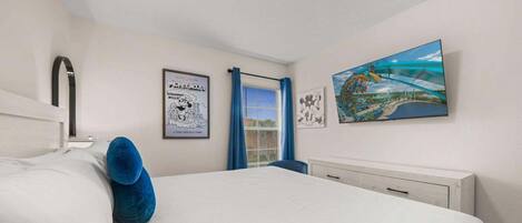Un dormitorio con cama, ventana con cortinas, un cuadro colgado en la pared y una lámpara en el techo.