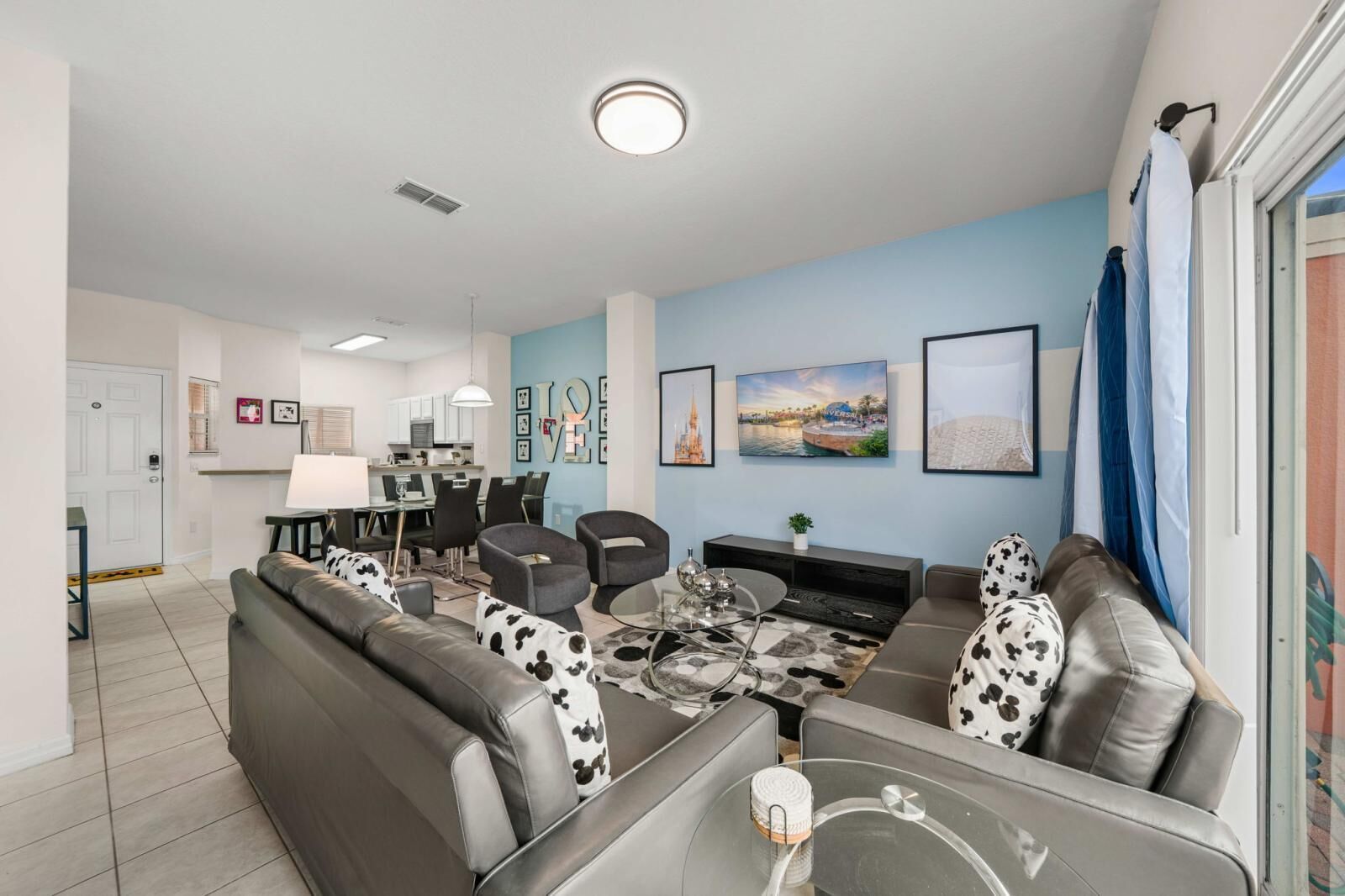 A modern living room with a sofa, armchairs, a coffee table, and a TV.