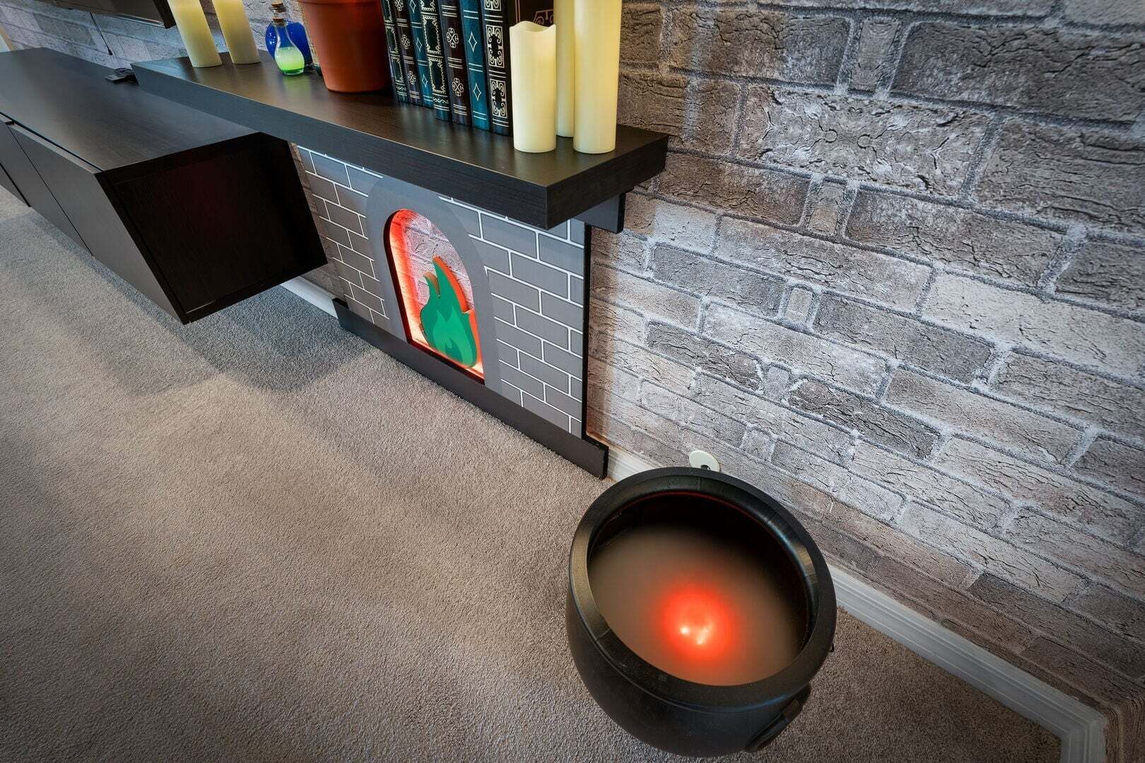 A fireplace with a brick wall, a black bench, and a decorative wall piece.