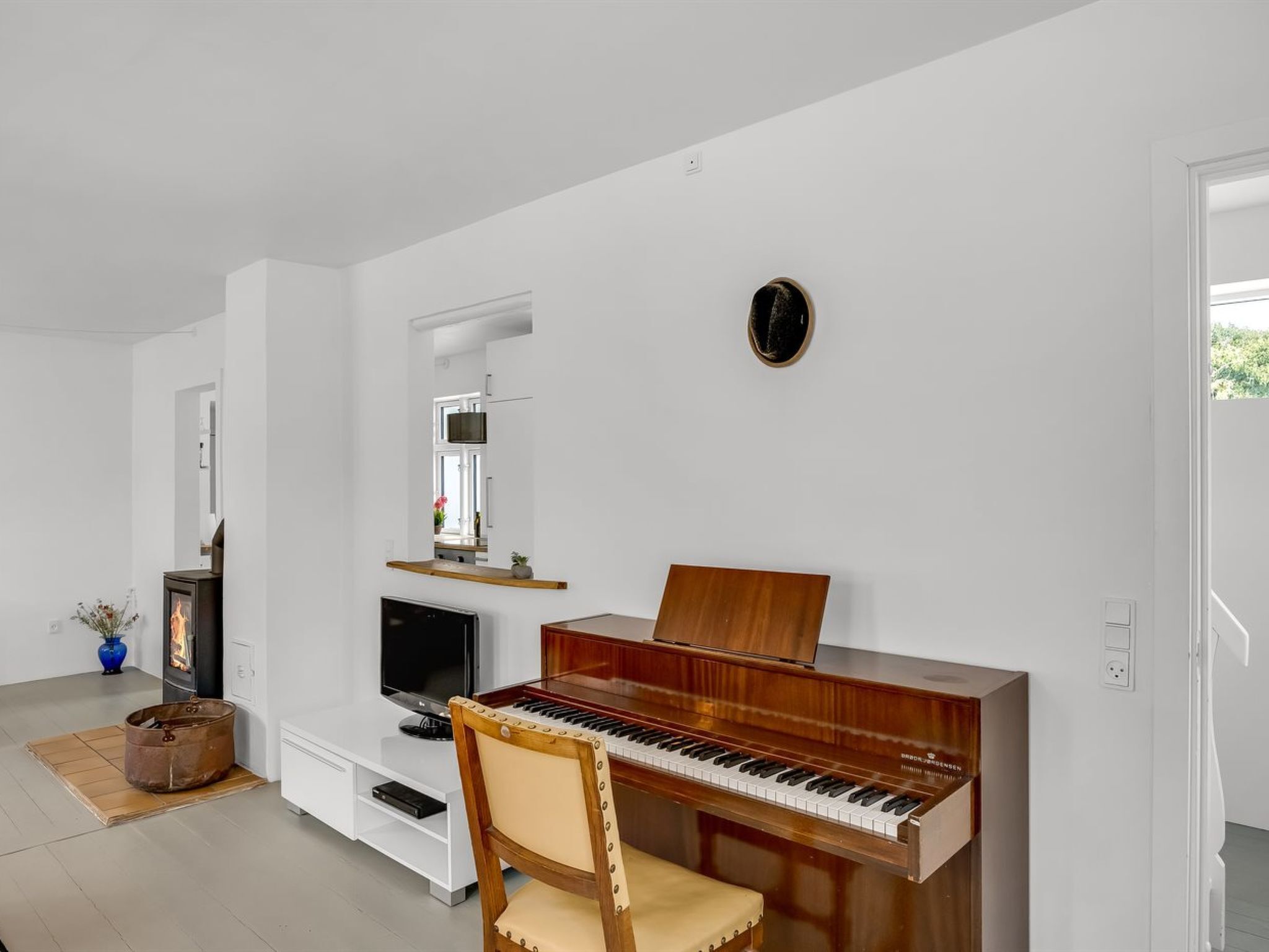 Un salon avec un piano, une télévision et une cheminée.