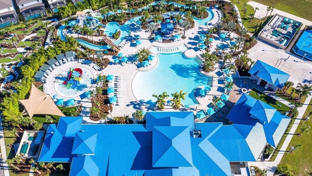 An aerial view of a resort with a central swimming pool, multiple lounge areas, and a variety of amenities. - Wonderful House 5 En-suites Free Access to Amazing Resort! (Davenport)