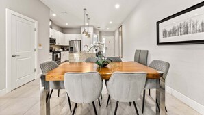 A modern kitchen with white cabinets, a stainless steel refrigerator, and a central island. - Ultra Convenient Stay > 5 min to Disney (Kissimmee)